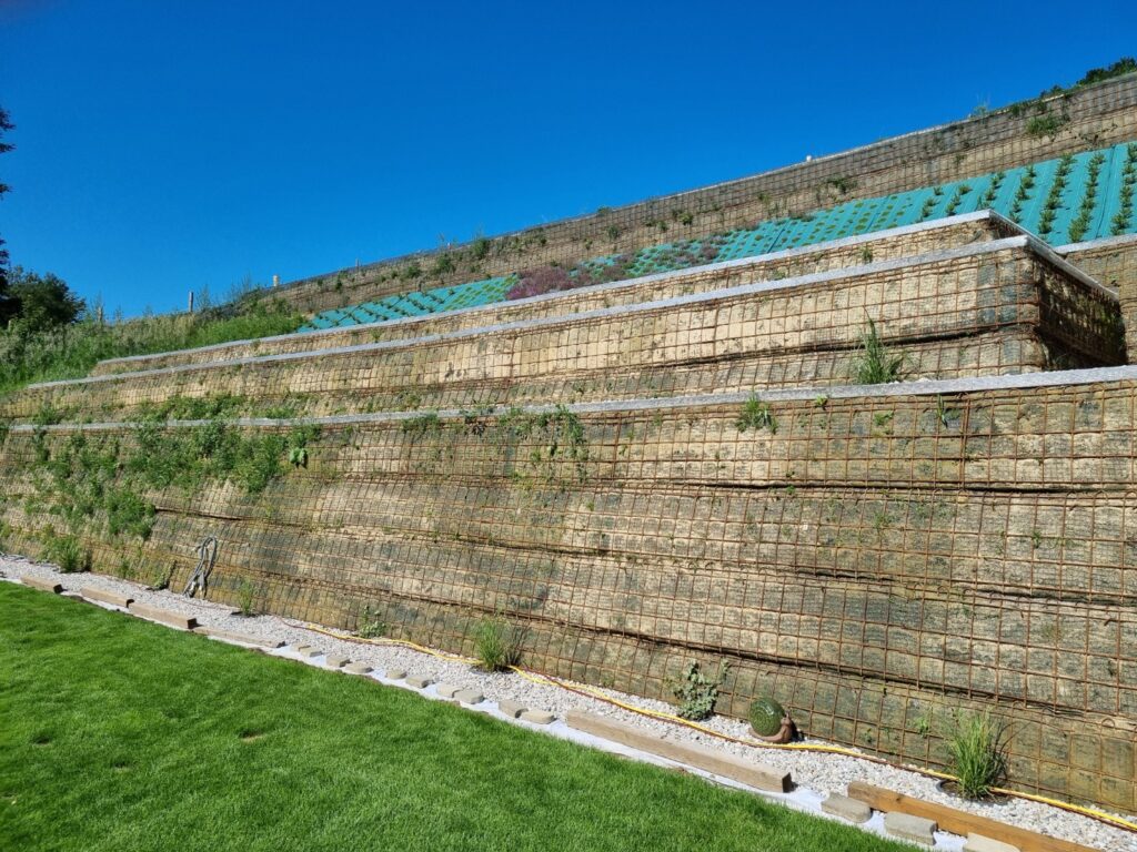 Stufenförmige Hangsicherung mit bewehrter Erde und Begrünung